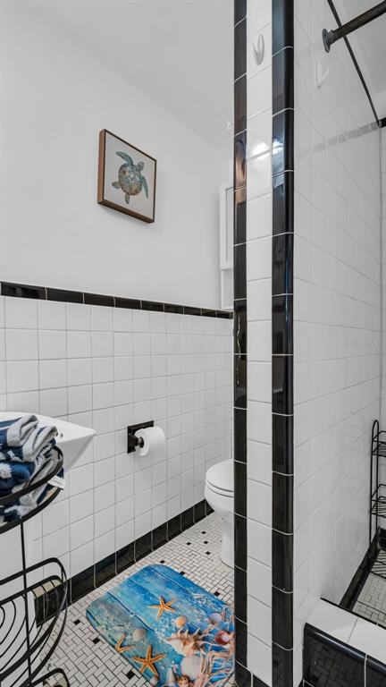Your crisp, clean bathroom features classic white subway tile with bold black accents, offering a refreshing space to start your day. The thoughtful details and coastal-inspired art create a welcoming retreat.