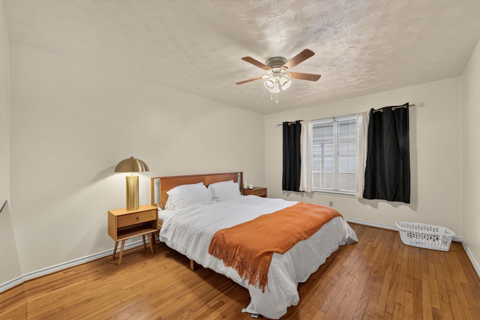 Unwind in your serene bedroom, where warm hardwood floors, modern lighting, and soft linens create the perfect retreat for restful nights.