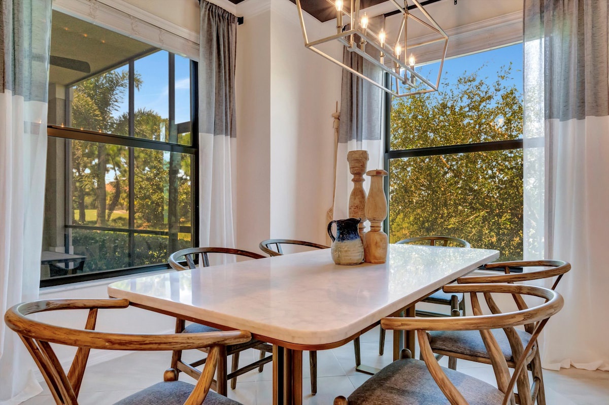 Gather around your private dining table beneath modern lighting, where large windows frame views of lush greenery—perfect for sharing meals and making memories together.