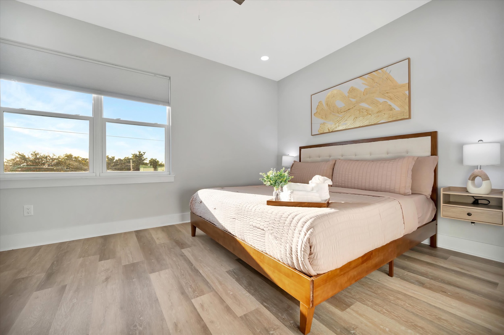 Sink into this serene bedroom where natural light fills your restful retreat. Wake up to peaceful views and drift off surrounded by warm wood tones and soft, inviting linens.