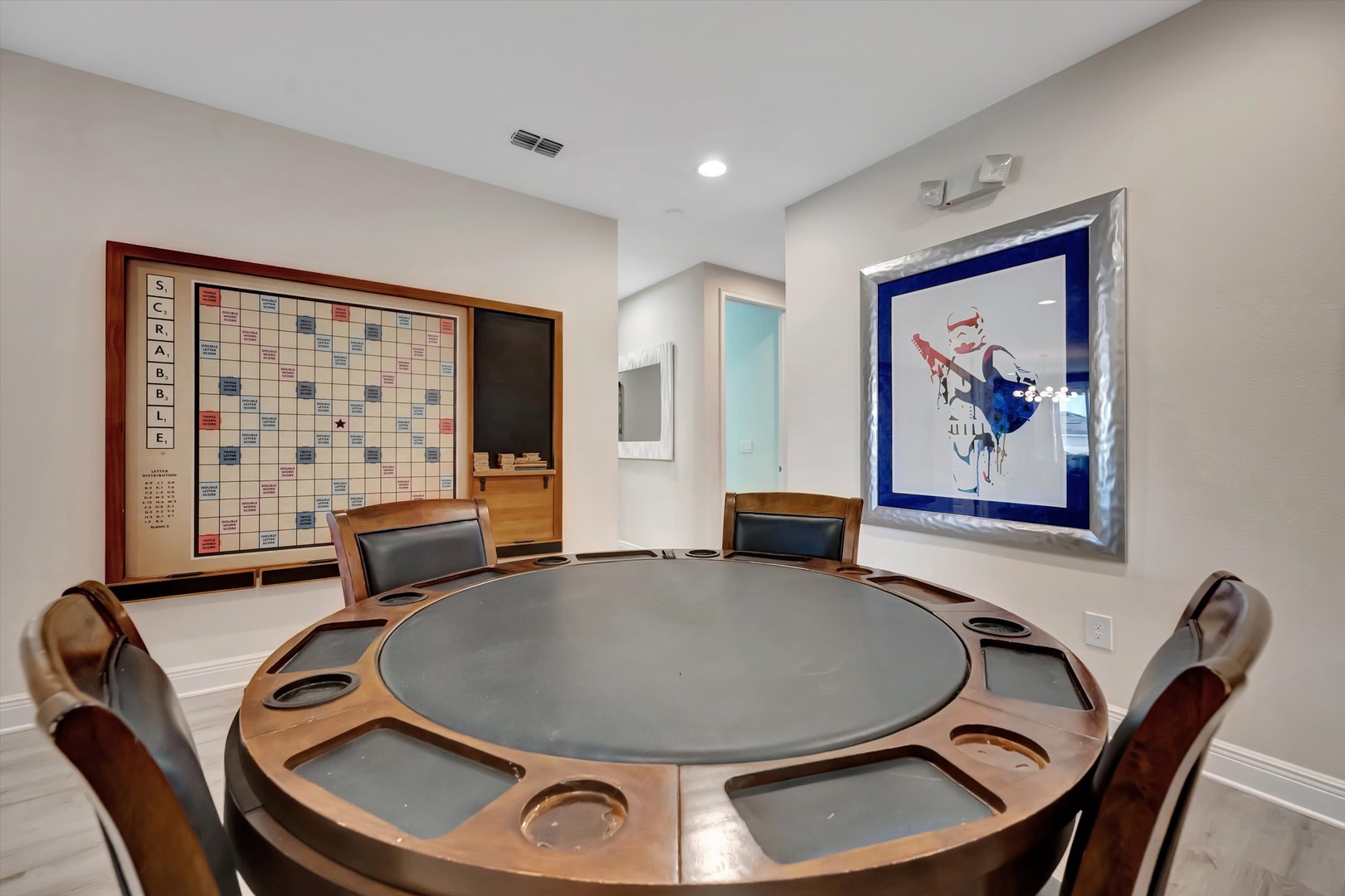 This dedicated game room invites friendly competition with a custom poker table and a classic Scrabble board displayed on the wall, perfect for evening entertainment.