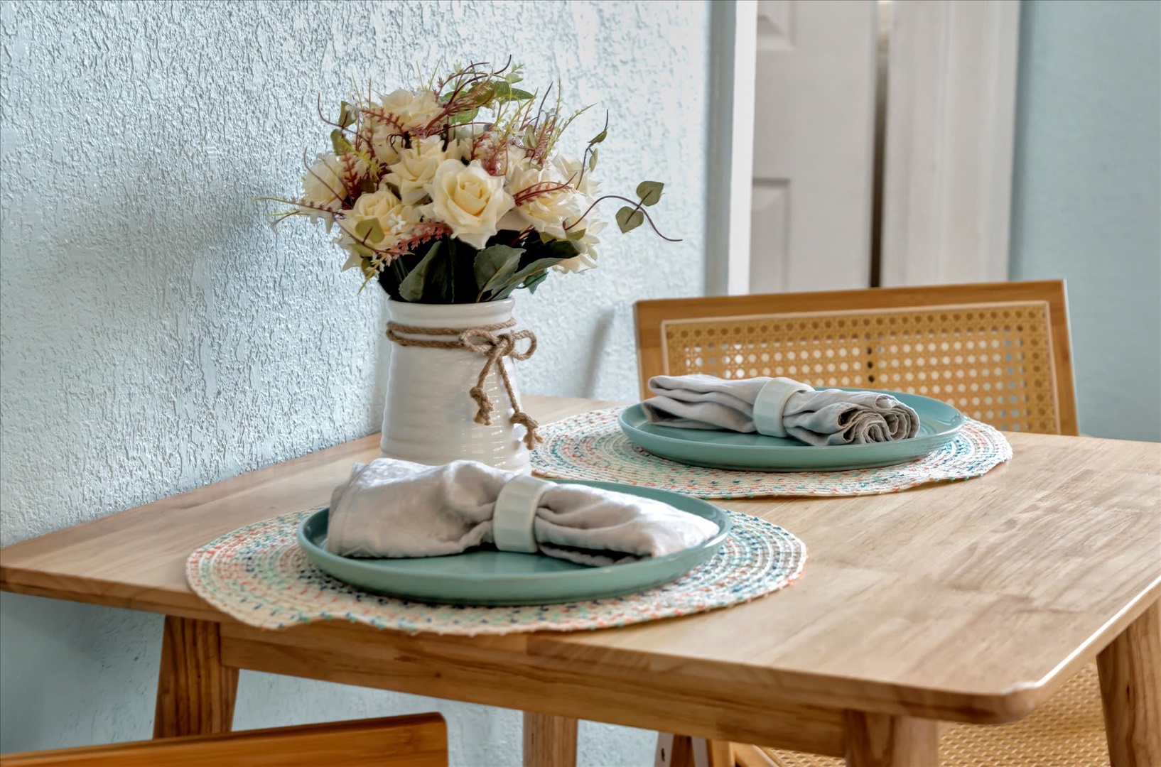 Your table is set and waiting with coastal-inspired touches—fresh flowers, woven placemats, and soft linens ready to welcome you home after a day of adventure.