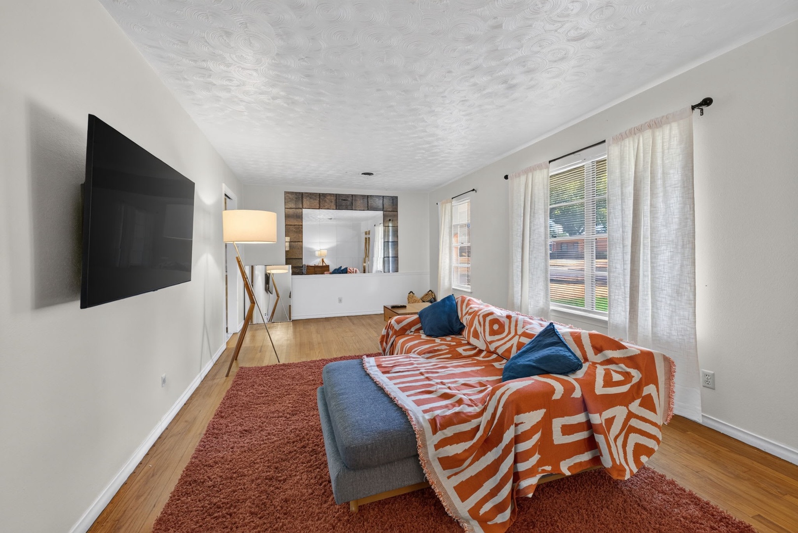 Relax in your bright living room, where warm hardwood floors and cheerful decor invite you to unwind. Cozy up on the sofa, enjoy the large TV, and let natural light fill your space.