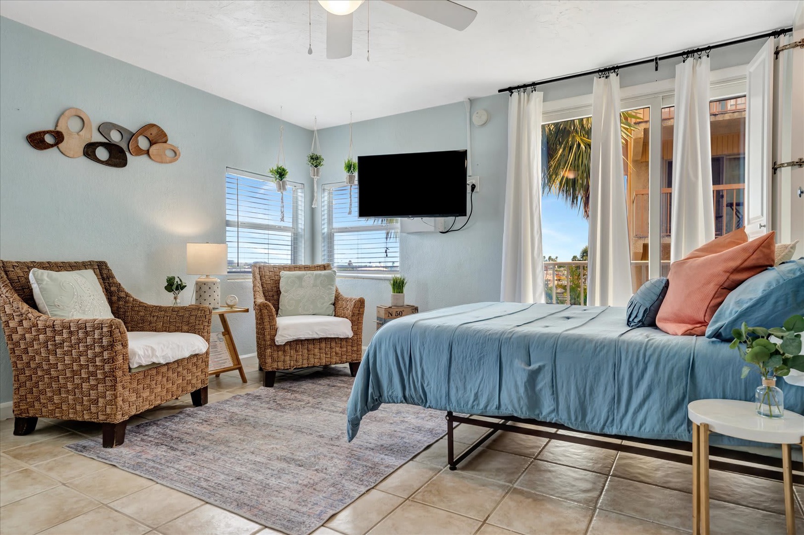 Relax in your coastal-inspired bedroom, where soft blue tones and breezy windows invite the outdoors in. Sink into cozy wicker seating or unwind on the plush bed after a day of adventure.