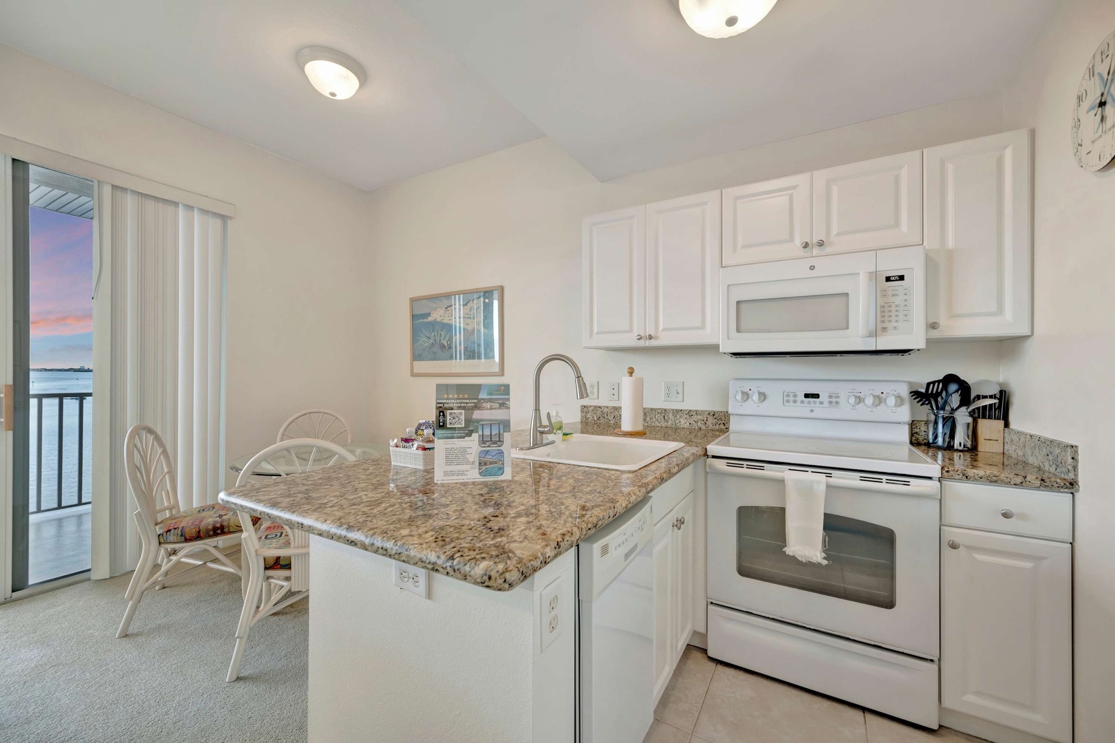 Step into your bright, fully equipped kitchen featuring granite countertops, white cabinetry, and everything you need to whip up meals during your stay. The island offers extra prep space and casual seating for quick bites.