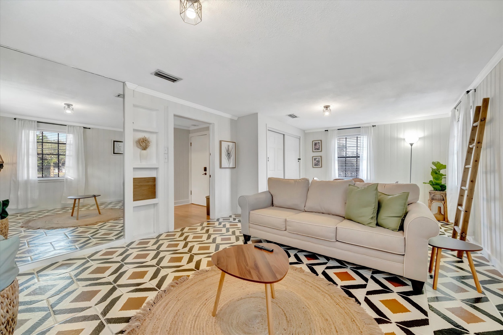 Sink into the plush sofa and feel instantly at home in this bright, stylish living space. The bold geometric floors and soothing natural light create a welcoming retreat where you can truly unwind.