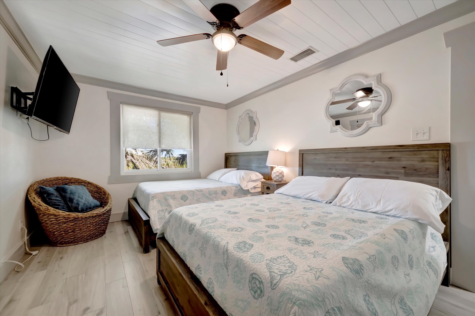 Drift off to sleep in this coastal-inspired bedroom with two comfortable beds, soft linens, and a gentle breeze from the ceiling fan overhead. Wake to natural light and unwind with your favorite shows on the flat-screen TV.
