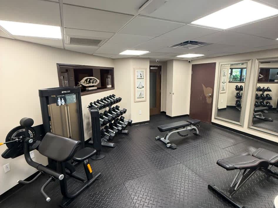 Stay on track with your fitness goals in your private workout space, equipped with free weights, benches, and strength-training equipment for a complete routine.