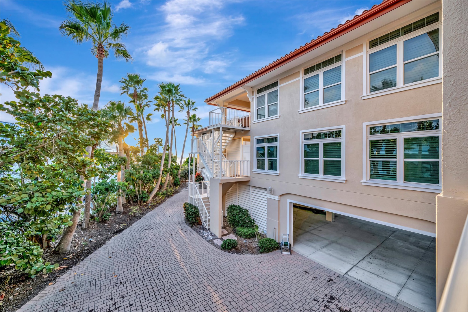A coastal retreat framed by swaying palms and tropical foliage, featuring bright, airy architecture and private balconies that invite relaxation in a serene beachside setting.