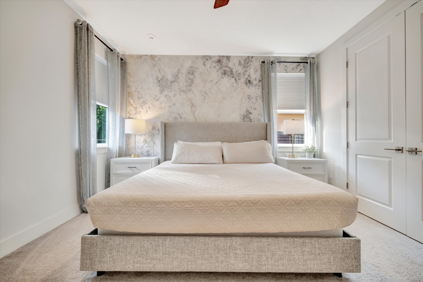 Drift off in this serene bedroom where soft neutral tones and gentle natural light create your perfect sanctuary. The textured accent wall and plush bedding invite you to unwind completely.