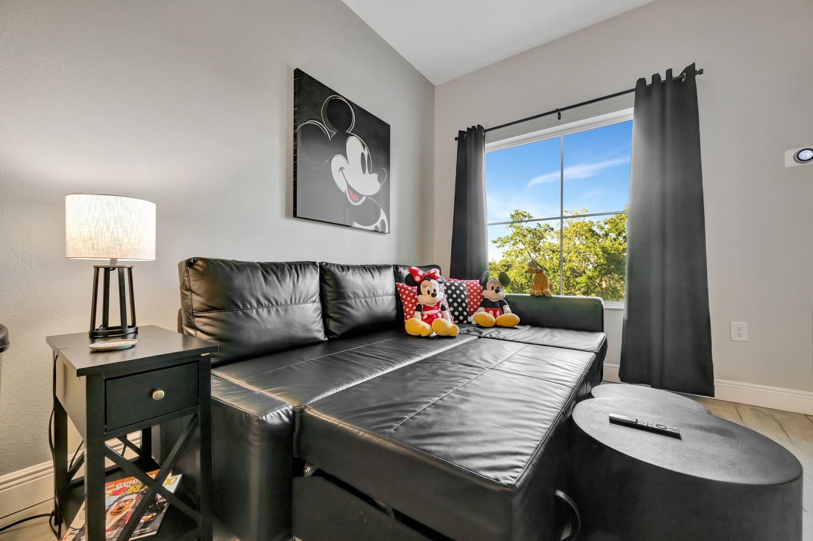 Relax on the sleek sectional sofa with plenty of space to unwind, while natural light and tree views through the window bring the outdoors in.