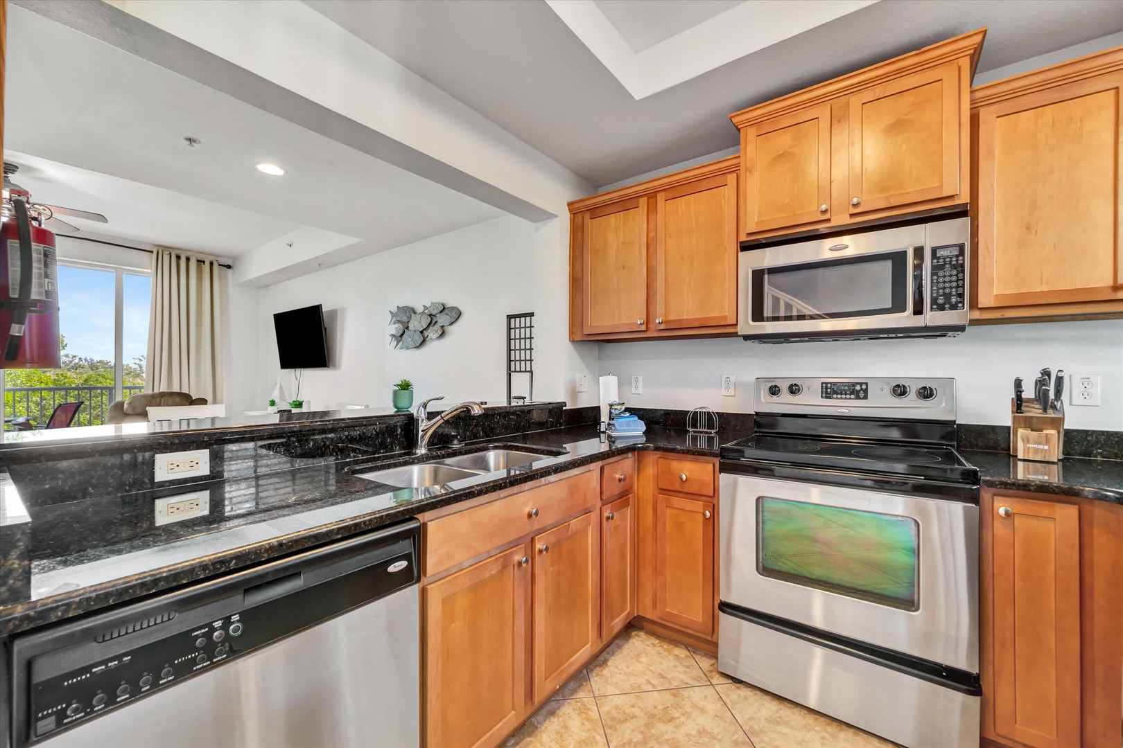 Your fully equipped kitchen features sleek granite countertops and stainless steel appliances, perfect for preparing meals while natural light streams through the windows overlooking the surrounding neighborhood.