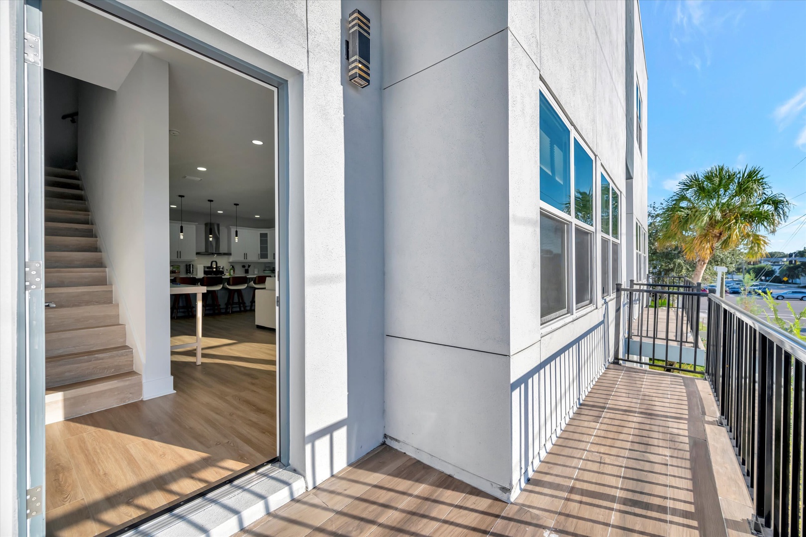 A modern exterior and balcony area showcasing contemporary design and proximity to nearby palm-lined streets and parking.