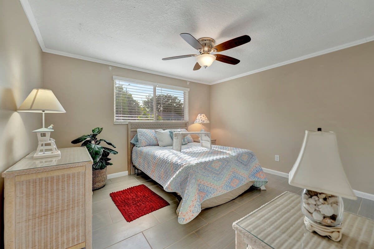 Your peaceful bedroom retreat features comfortable sleeping arrangements, soft natural light, and a ceiling fan to keep you cool and comfortable during your stay.