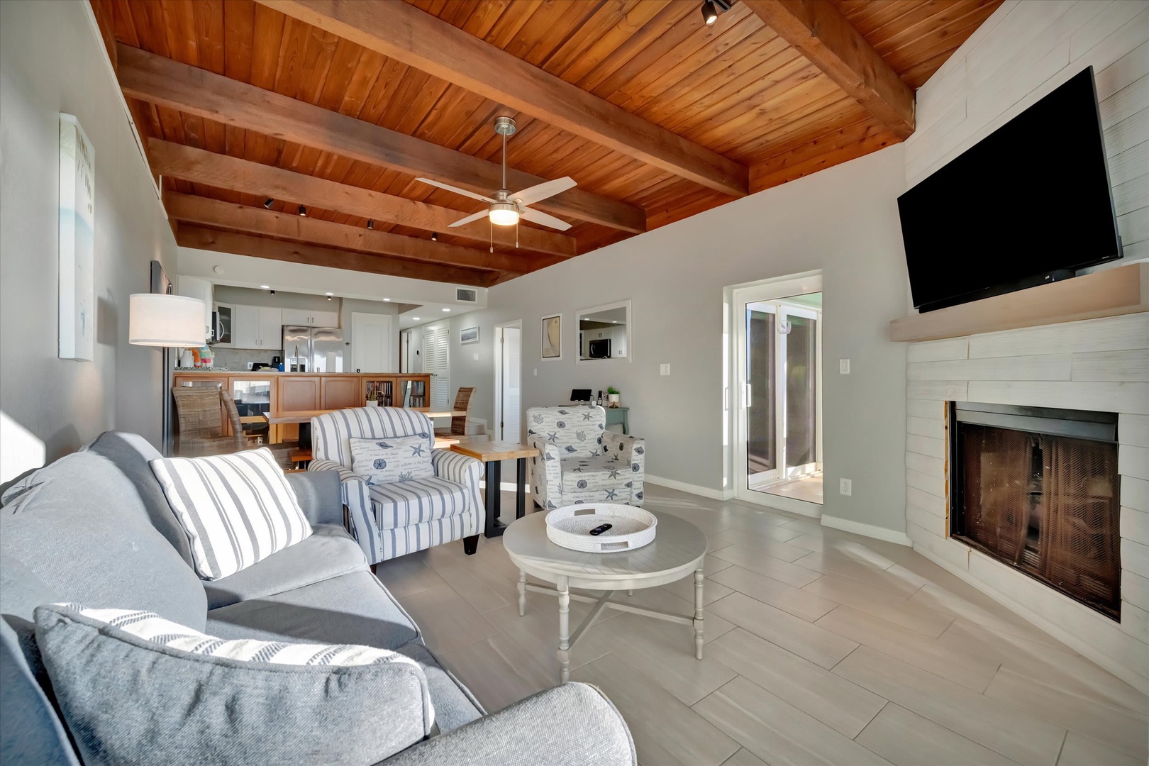 Sink into plush seating beneath stunning vaulted wood ceilings. The open layout connects your living space to the kitchen, while the cozy fireplace invites relaxation after a day exploring.