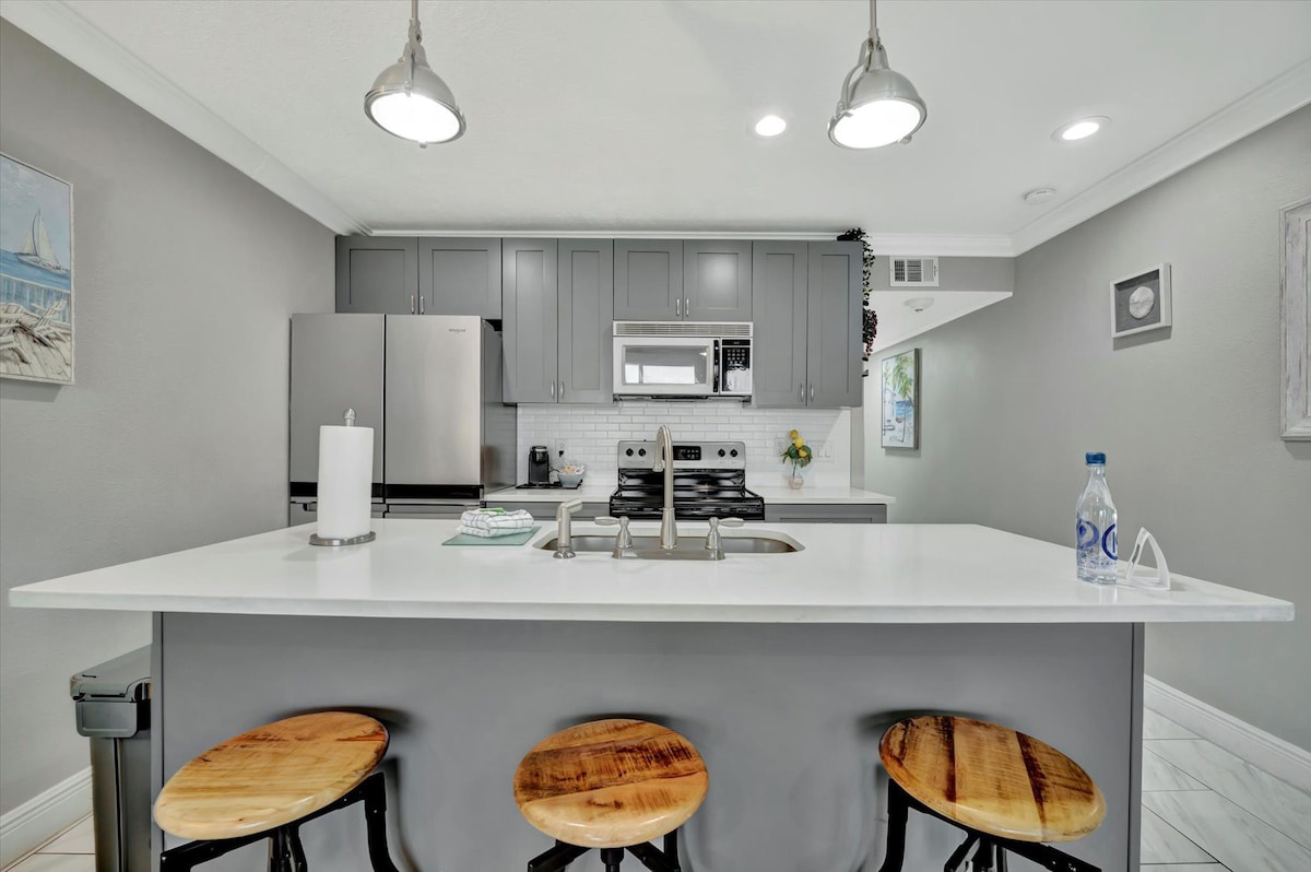 Gather at your island with café seating, modern gray cabinetry, and everything you need to whip up your favorite vacation meals in this bright, welcoming kitchen.