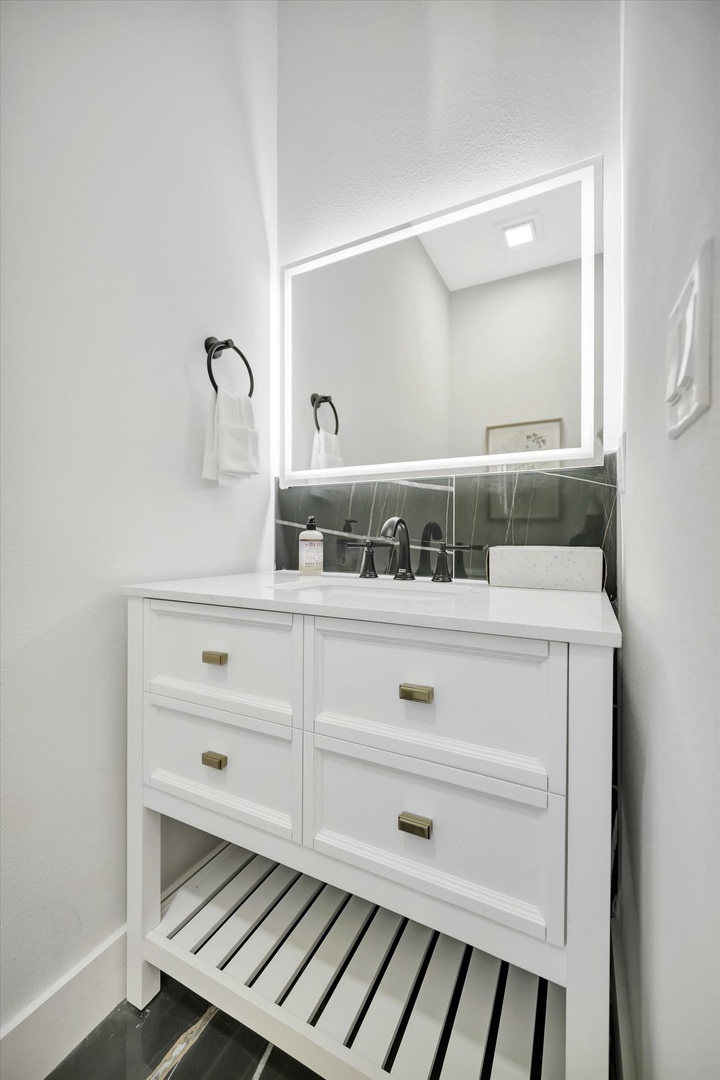Step into a bright, modern bathroom with crisp white fixtures and a backlit mirror that adds a soft glow to your morning routine.