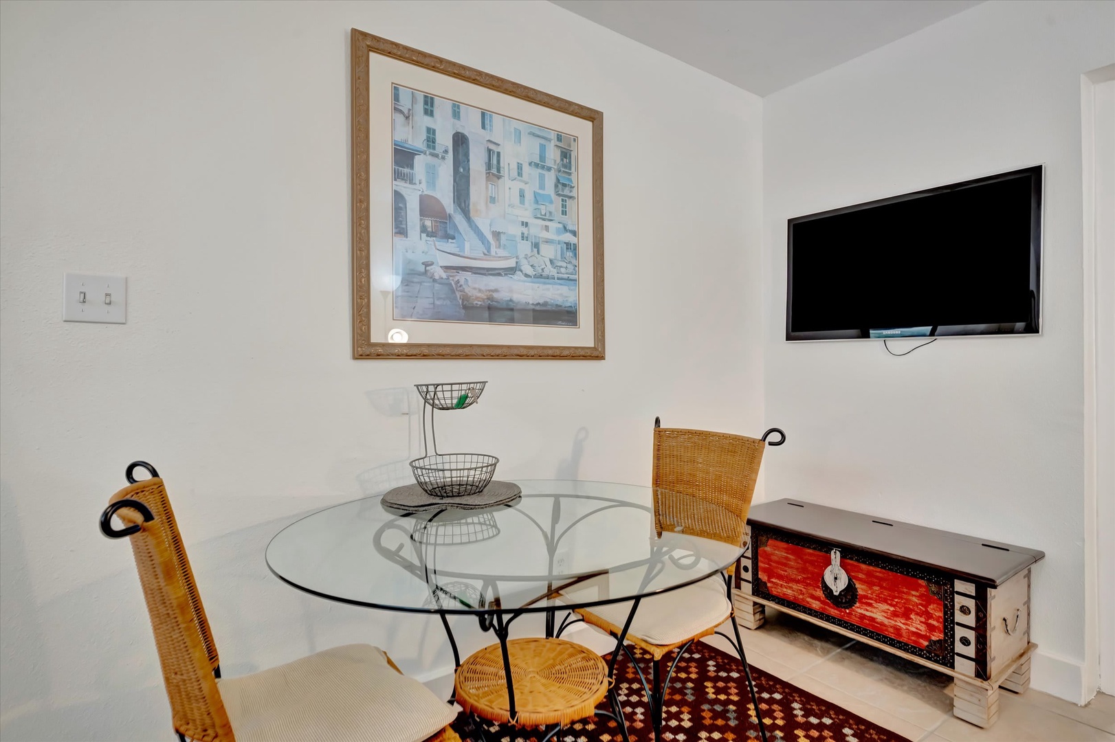 Your bright dining nook features a charming glass-top table paired with woven bistro chairs, perfect for morning coffee or casual meals. Catch up on your favorite shows or unwind after exploring nearby attractions.