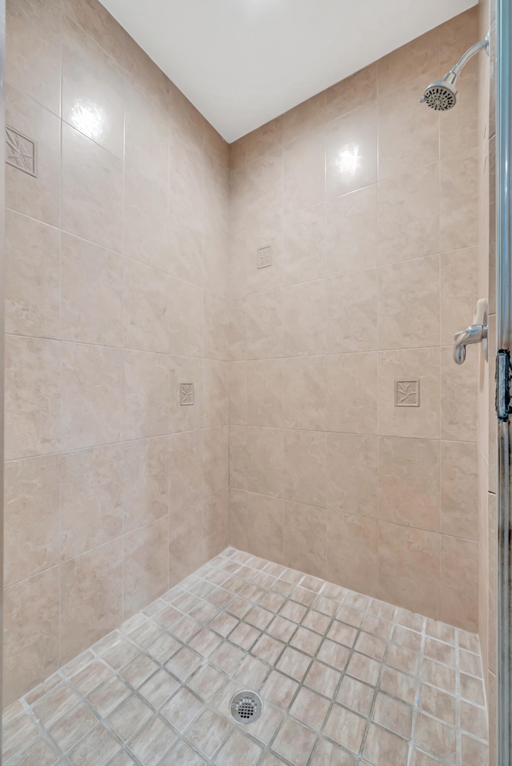 Step into a spacious walk-in shower with elegant tile work and modern fixtures for your daily refresh.