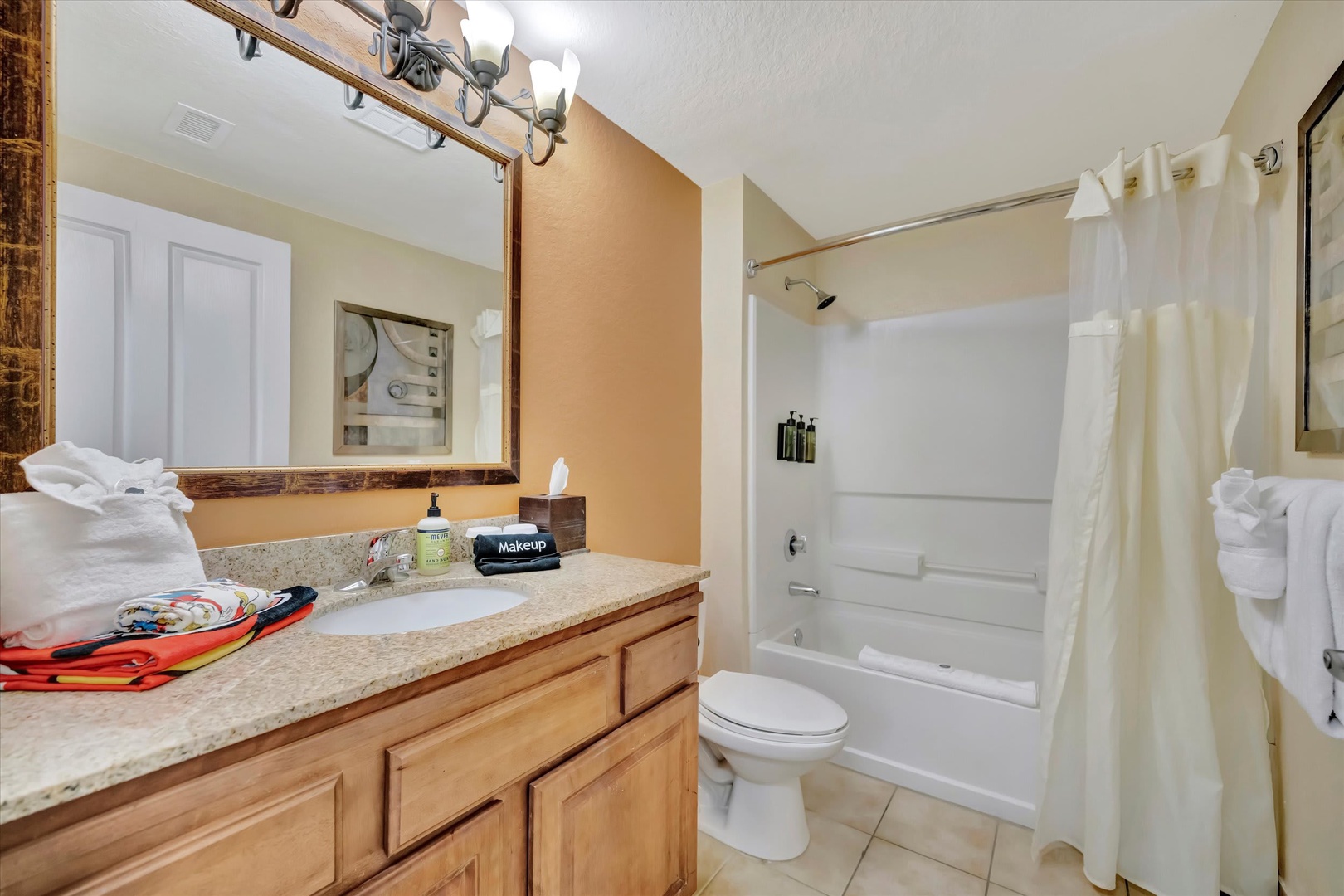 Your private bathroom features a shower-tub combo, fresh towels, and plenty of counter space for your toiletries—a clean and functional space to refresh after a day of adventure.