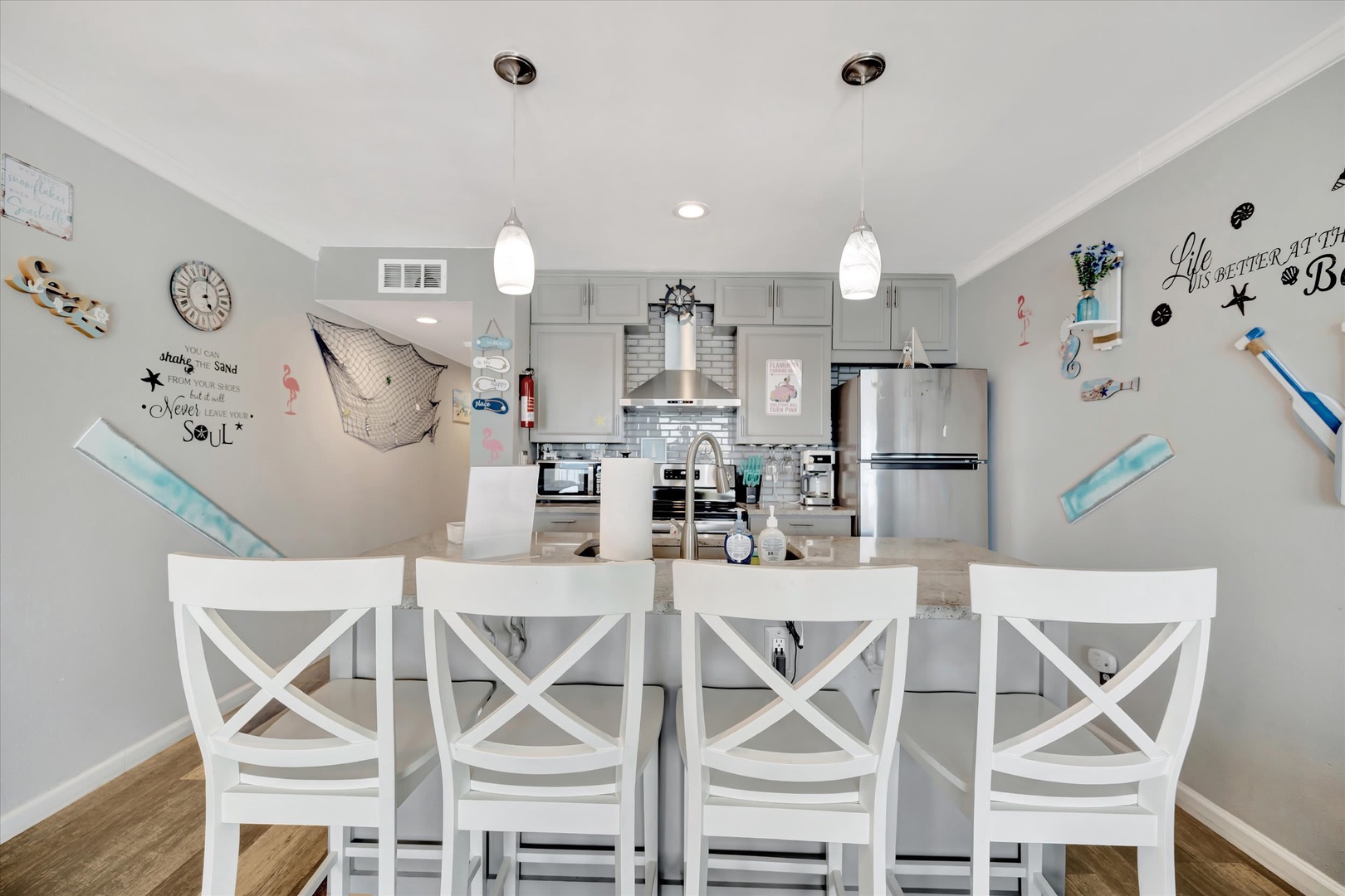 Gather around the island for meals and laughter in this bright open kitchen with coastal charm, stainless steel appliances, and beachy décor that invites you to unwind.