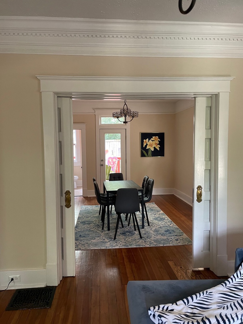 Step through elegant French doors into your dining space, where warm hardwood floors and classic molding set the stage for memorable meals together.