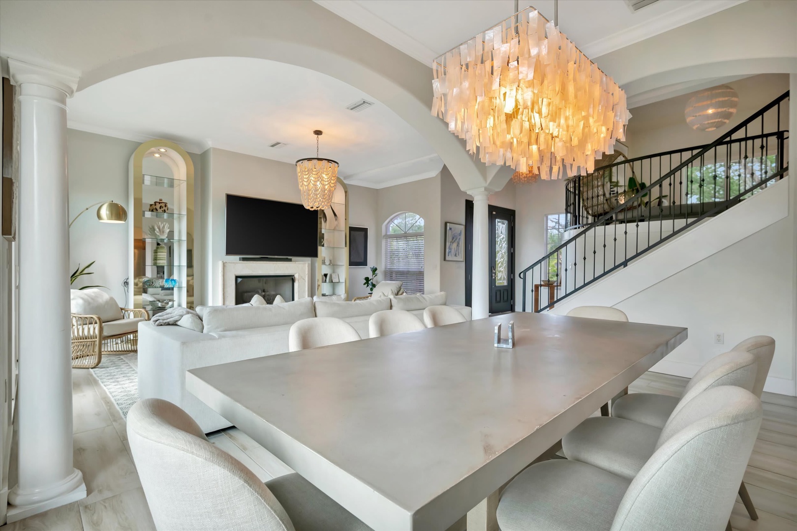 Elegant dining space with stunning chandelier and arched windows floods the open layout with natural light, perfect for memorable meals with loved ones.