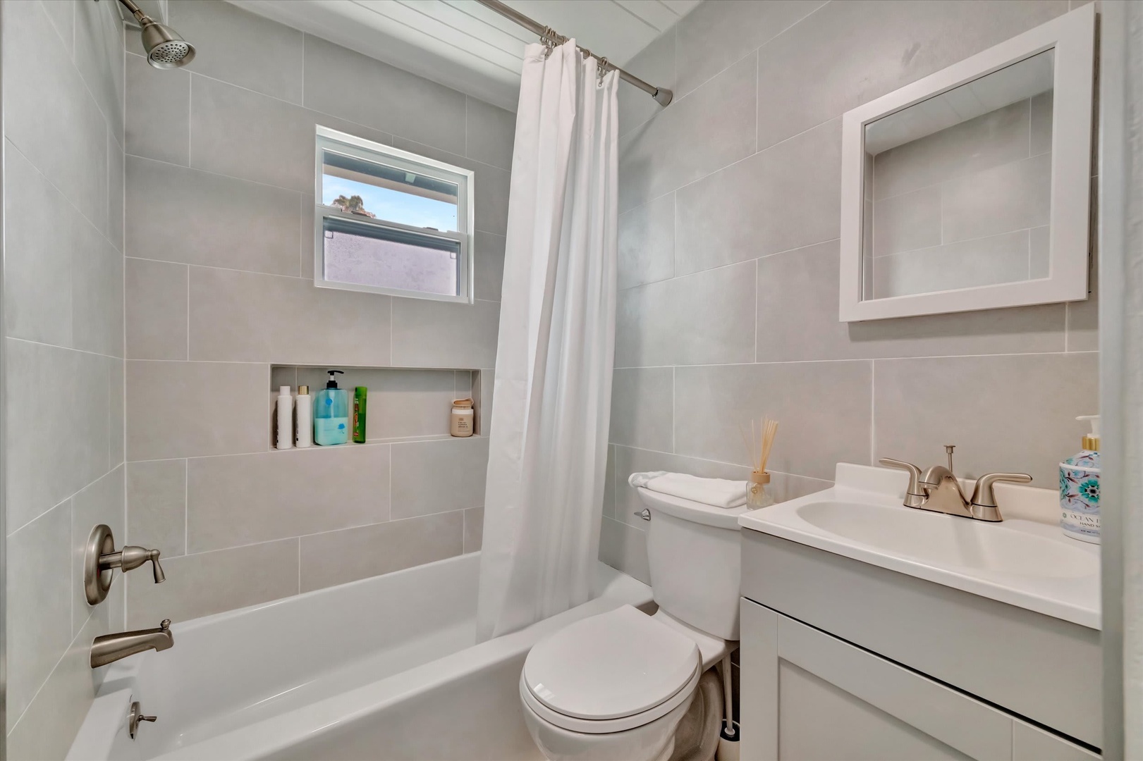 Step into a bright, beautifully tiled bathroom where everything is ready for you. Soft towels, a serene palette, and a spotless space make this your personal retreat after a day of exploring.