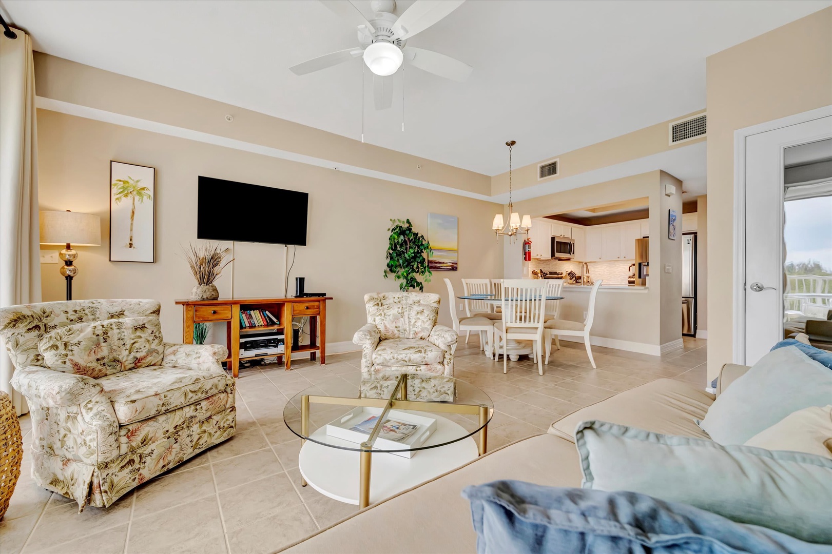 Your bright, open-concept living space features soaring ceilings and a ceiling fan for comfort. Relax on the cozy seating while enjoying the seamless flow into the dining area and fully equipped kitchen.