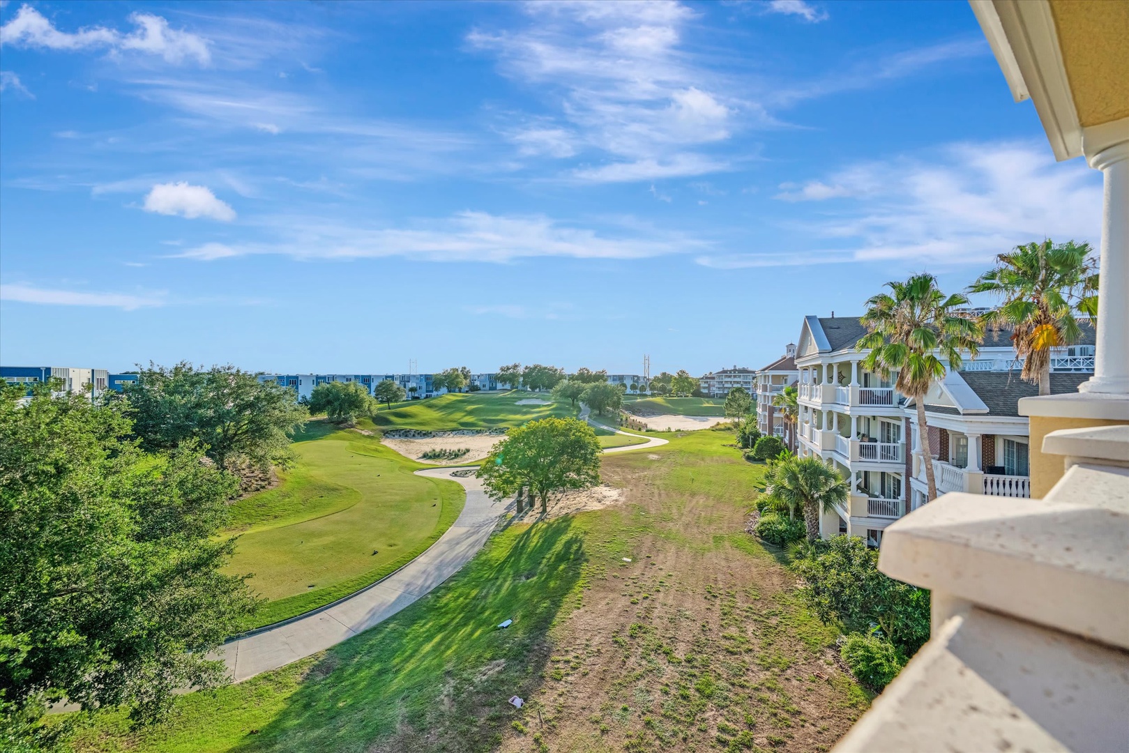 This property is situated in a serene coastal resort community with lush golf course fairways, swaying palms, and glimpses of the ocean beyond.