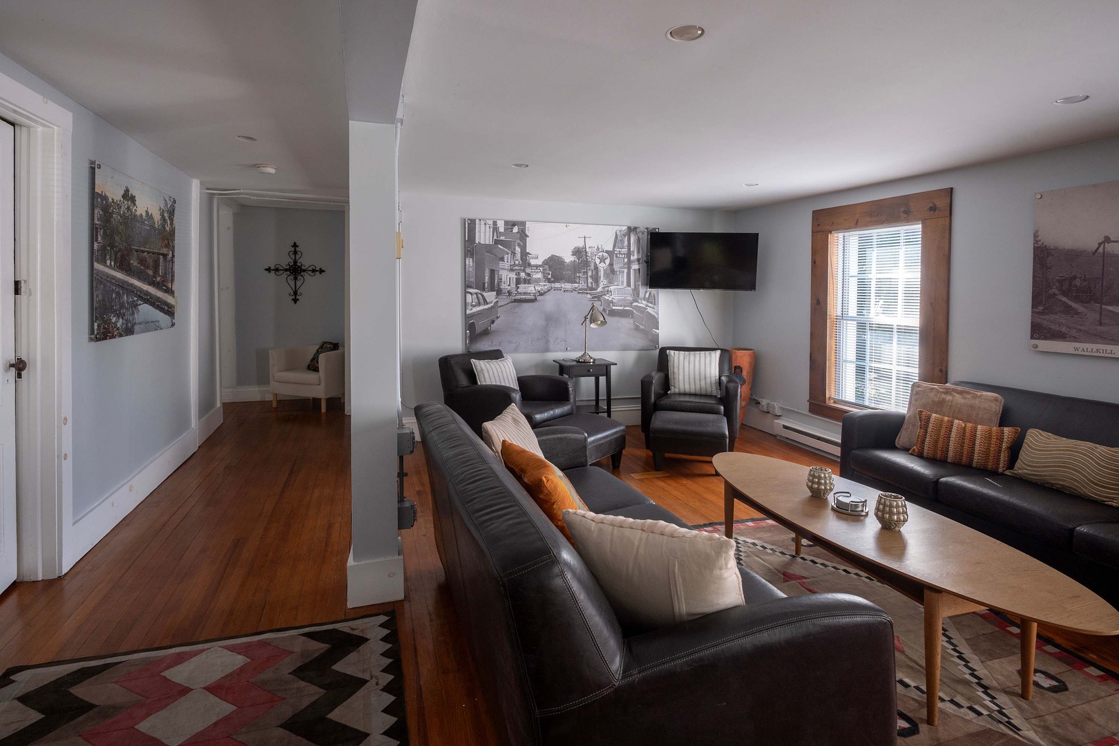 Settle into this welcoming living space where you'll find plenty of seating, warm hardwood floors, and natural light streaming in through the window—perfect for unwinding after your day's adventures.