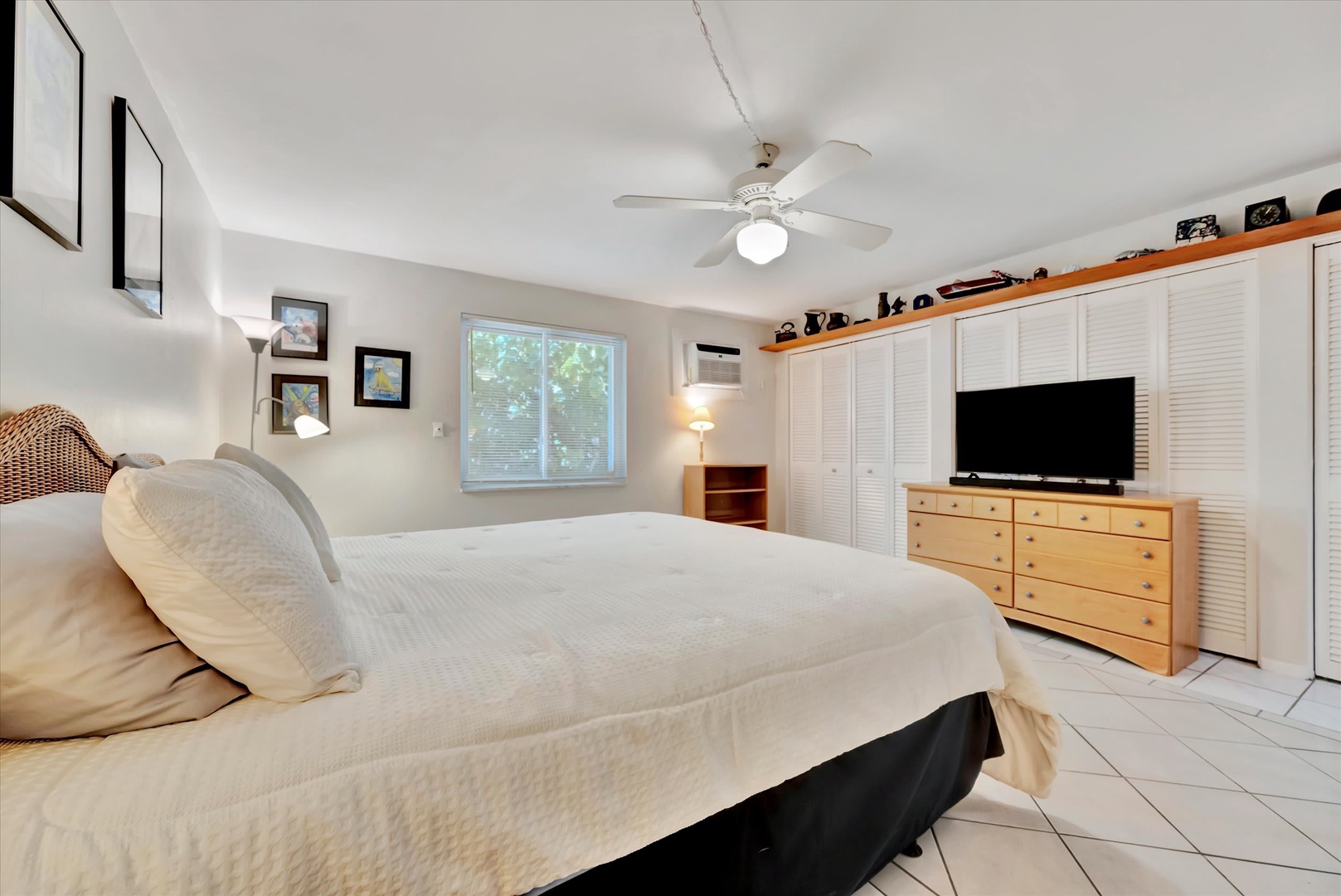 Drift off to sleep in this bright, inviting bedroom with a ceiling fan overhead and ample storage. Natural light from the window creates a peaceful, comfortable retreat for your getaway.