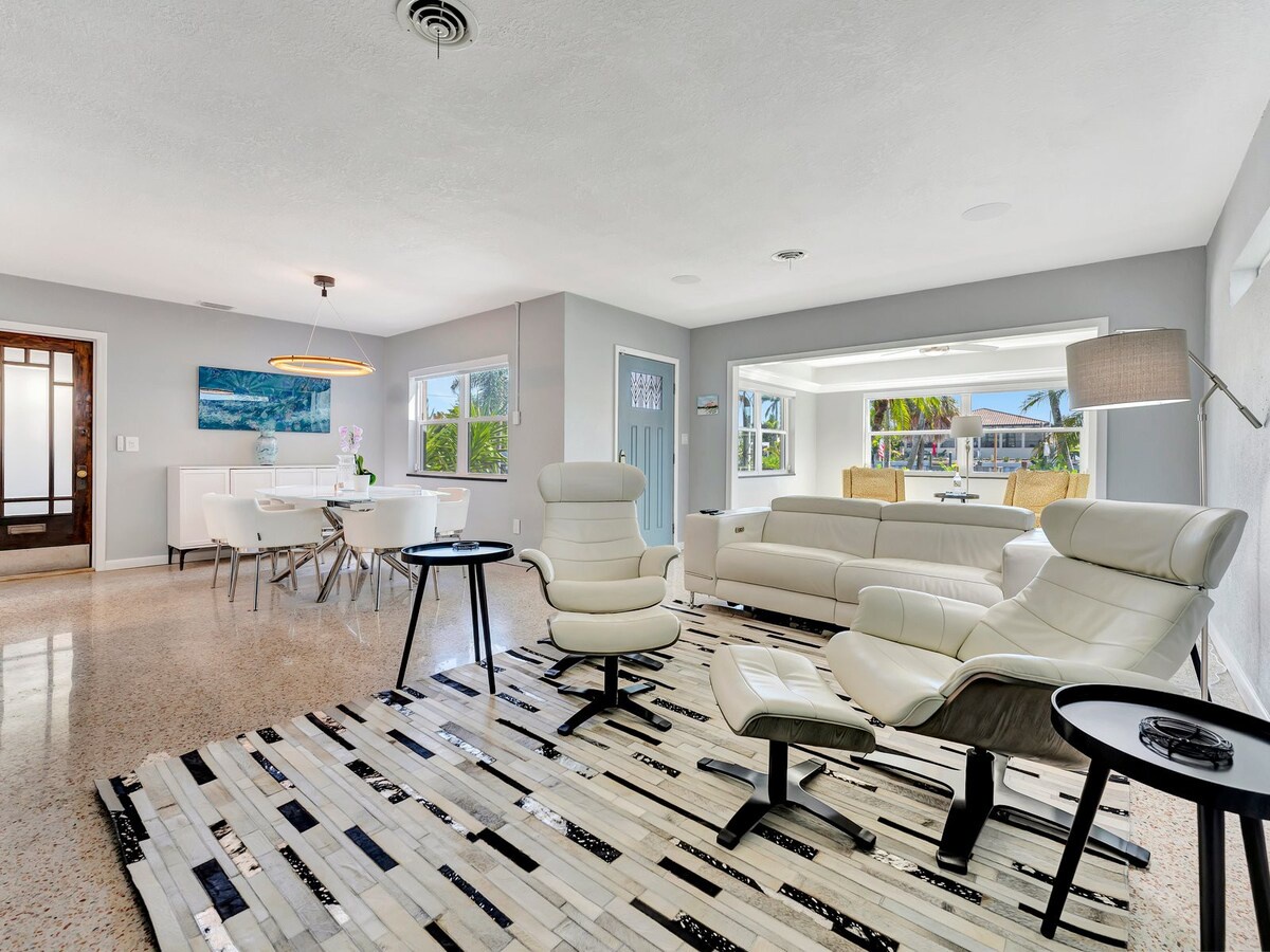 Relax in your bright, modern living space where sleek furnishings meet serene views of swaying palms—perfect for unwinding after sun-soaked days.