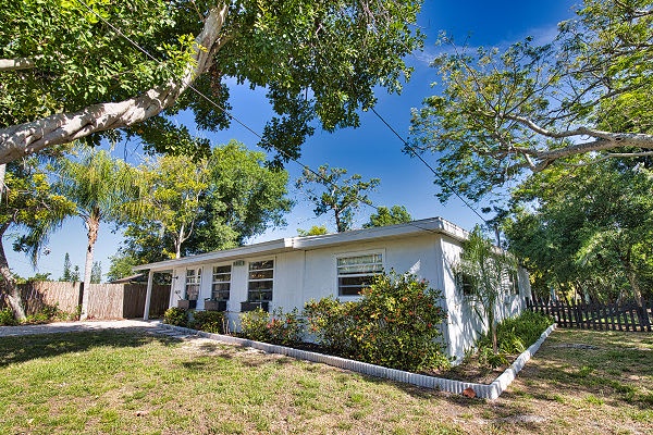 Nestled beneath towering trees and surrounded by lush greenery, this charming property welcomes you to a peaceful retreat in a vibrant Florida neighborhood.
