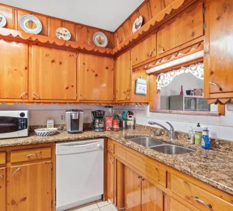 Step into your fully equipped kitchen with warm wood cabinetry, granite countertops, and modern appliances ready for you to craft home-cooked meals during your stay.