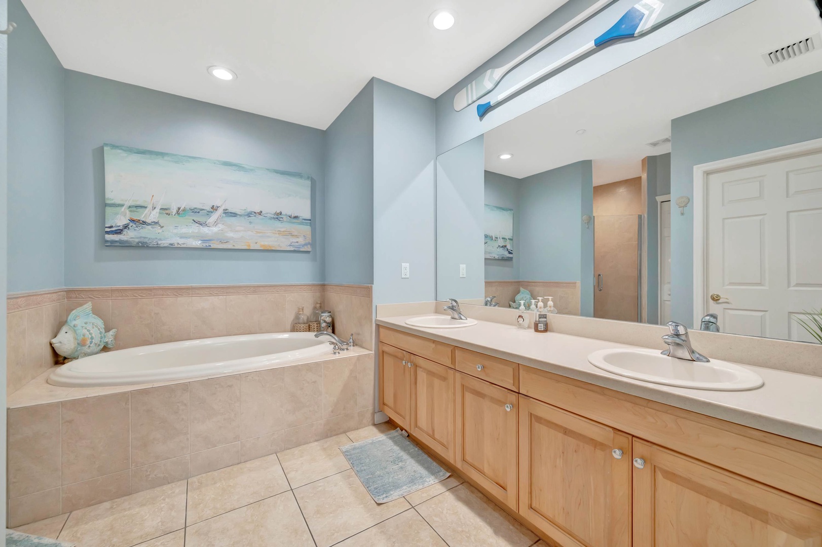 Unwind in your spacious bathroom with a soaking tub, dual sinks, and coastal charm that invites relaxation after a day of adventure.