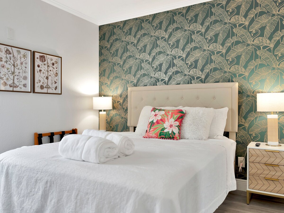 Sink into crisp white linens and plush pillows in your private retreat, where tropical-inspired accents and soft lighting create a serene escape just for you.