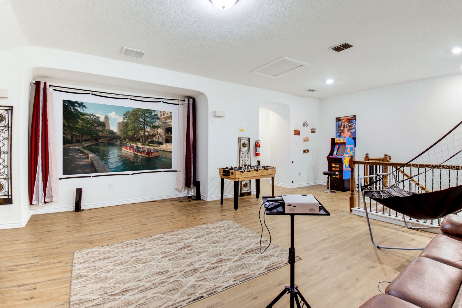 Your game room features a fun mix of entertainment—foosball, arcade games, and a large projector screen—perfect for friendly competitions and movie nights during your stay.