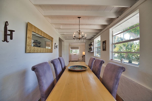 Gather around your private dining table beneath elegant exposed beams and a warm chandelier. Natural light fills the space, creating the perfect setting for shared meals and conversation.