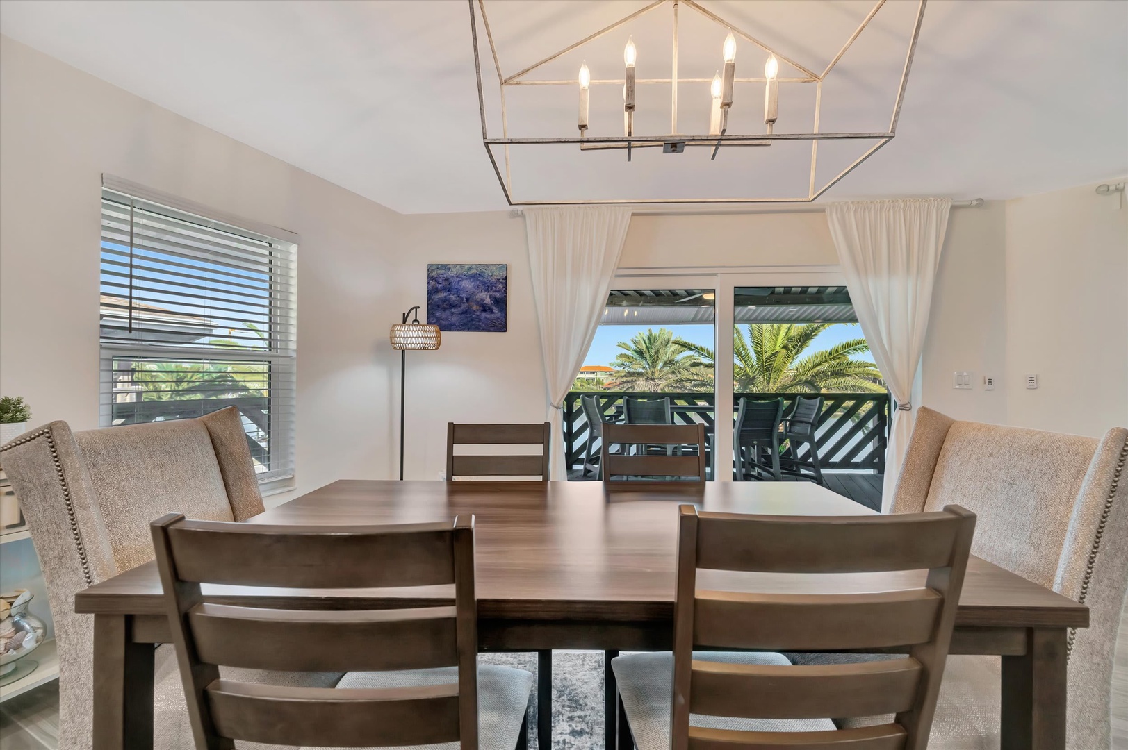 Step into your bright dining room where a statement chandelier sets the mood for memorable meals. Through your window and glass doors, glimpse the swaying palms outside—a peaceful reminder that paradise is just steps away.