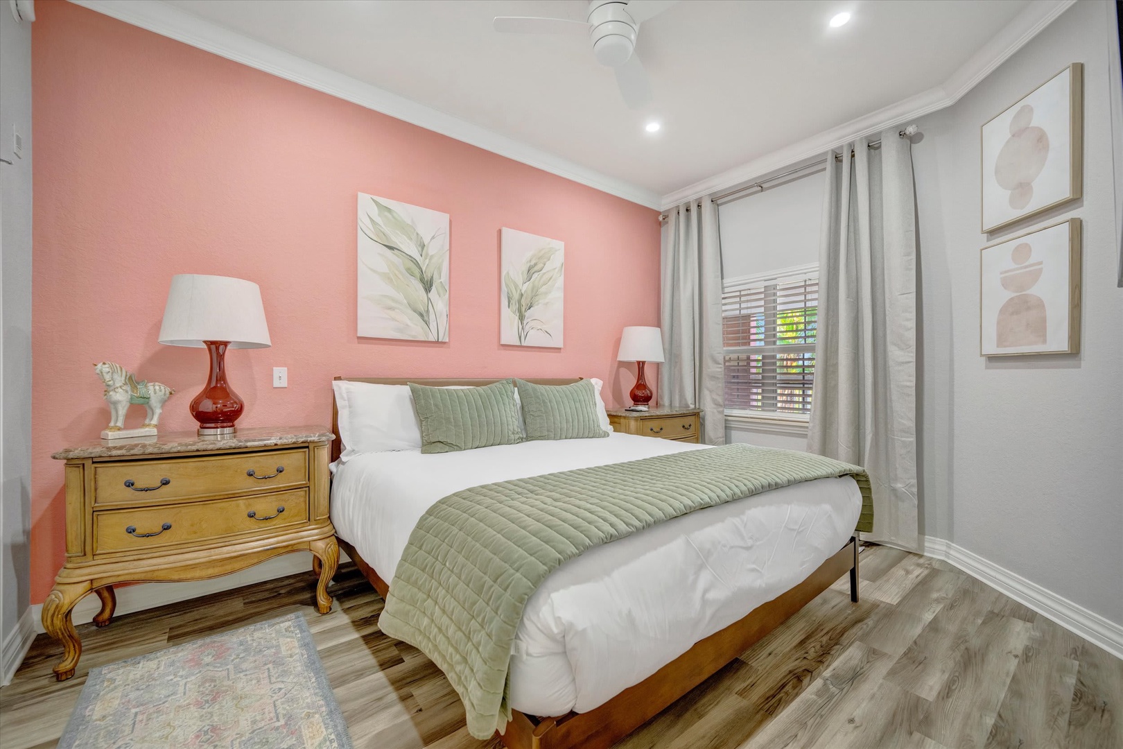 Unwind in your serene retreat with soothing coral walls, crisp linens, and vintage-inspired furnishings that create a peaceful sanctuary for restful nights.
