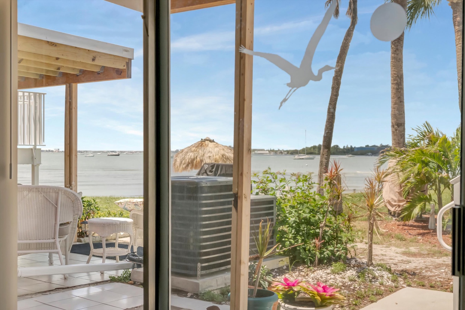 Step through your door to discover serene waterfront views stretching across tranquil waters, where palm trees sway and tropical gardens meet a cozy private patio perfect for morning coffee.