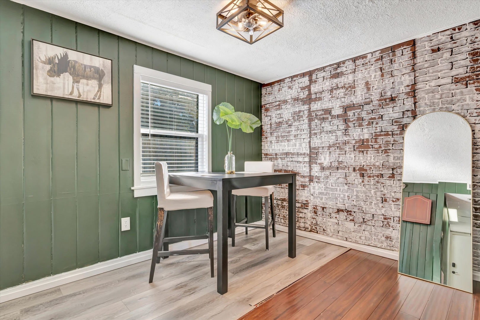 Cozy workspace with rustic exposed brick and sage paneling—your perfect spot to catch up on emails or sketch out tomorrow's adventure.