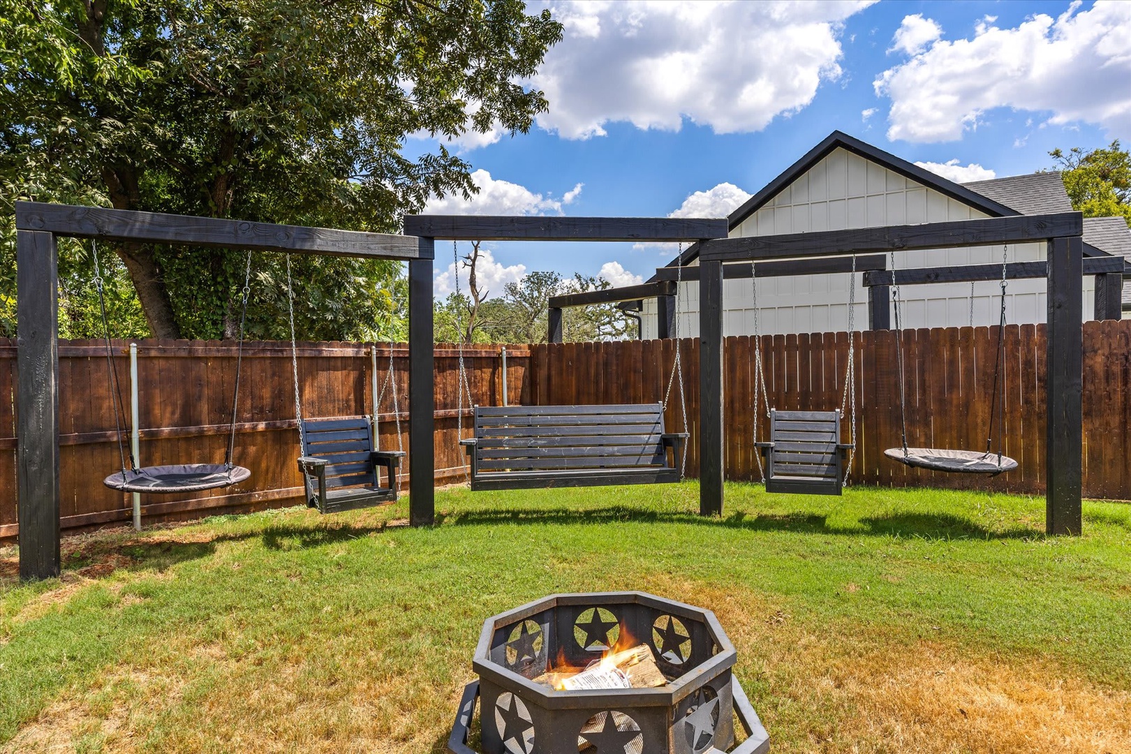 Picture yourself swinging gently under the open sky, gathering around the fire pit as the sun sets. This inviting backyard space is perfect for creating memories together.