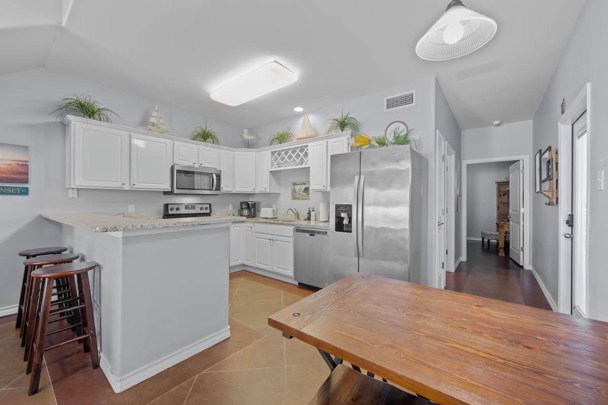 Your full kitchen welcomes you with sleek white cabinets, granite countertops, stainless steel appliances, and a roomy island with bar seating—perfect for whipping up meals or lingering over morning coffee.