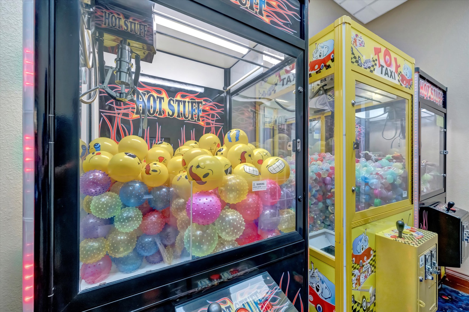 A dedicated game room featuring classic arcade-style claw machines, ready for your next winning moment. Test your skills and bring home fun prizes from these colorful, nostalgic games.