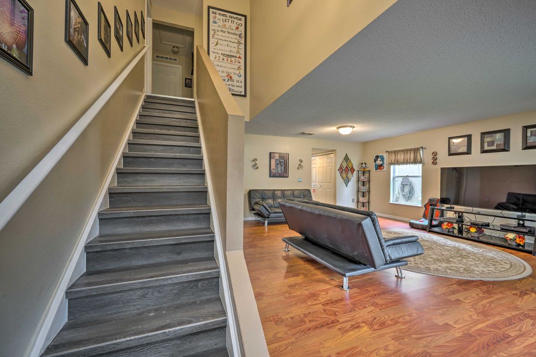 Spacious living area with sleek modern seating and warm wood floors invites you to unwind after a day of adventure. Framed art adds personality to this welcoming retreat.