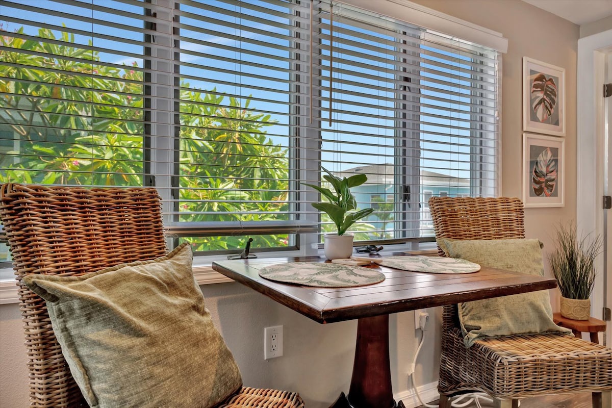 Settle into your cozy dining nook with woven chairs and a view of tropical greenery just outside your window, where you can enjoy morning coffee or evening meals.