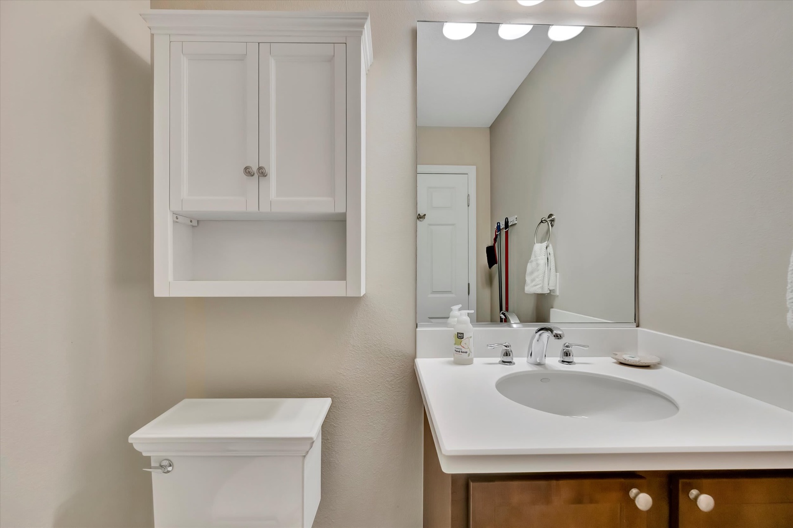 Step into your spotless bathroom, where a gleaming vanity and ample storage await. Freshen up under bright lighting before your next adventure—this clean, organized space makes every morning feel effortless.