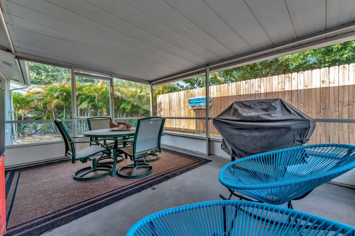 Gather around your covered patio for meals and relaxation, where a dining table and modern seating invite you to enjoy the tropical garden beyond. The built-in grill makes it easy to cook and dine outdoors in comfort.